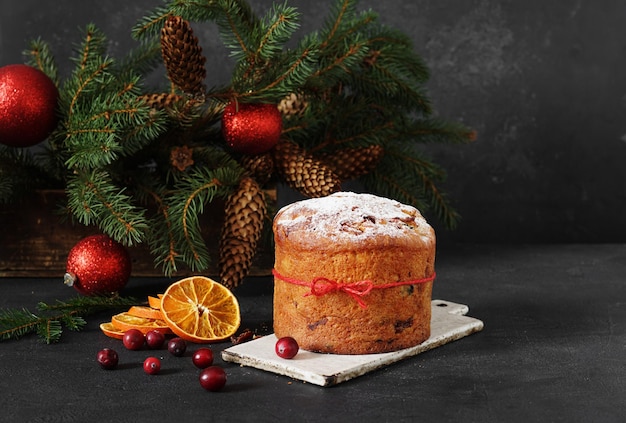 Panettone fatto in casa su sfondo scuro con albero di natale torta di natale italiana tradizionale