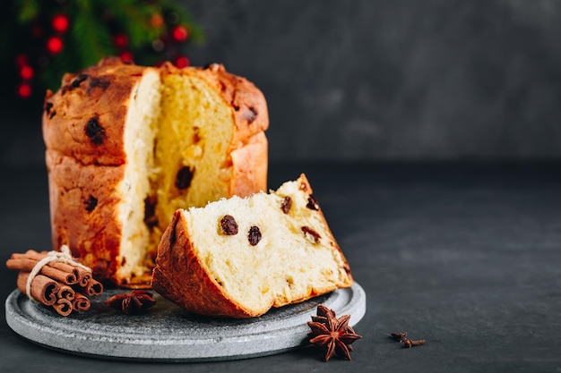 Panettone natalizio tradizionale con frutta secca su sfondo di pietra scura