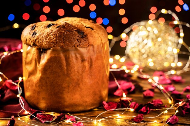 Panettone torta italiana e luce di Natale su un tovagliolo rosso