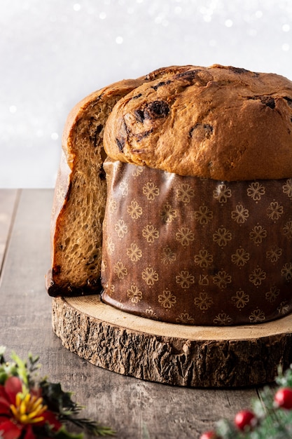 Panettone tradizionale italiano per Natale su tavola di legno e fondo glitterato