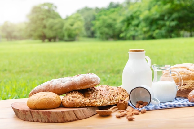 Pani e latte sulla tabella di legno con priorità bassa verde vaga del giardino.