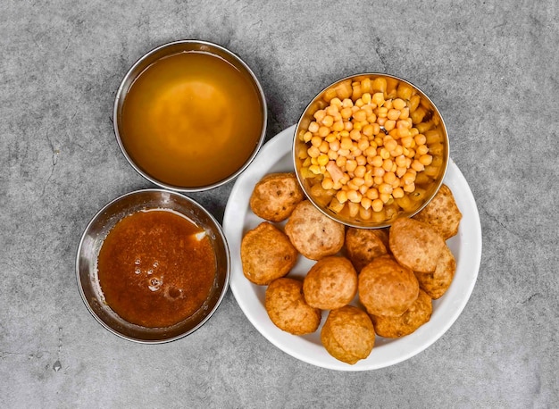 Pani puri o gol gappay con chutney di acqua piccante dahi chnnay e piatto servito con salsa isolato su sfondo vista dall'alto del cibo delle spezie indiane