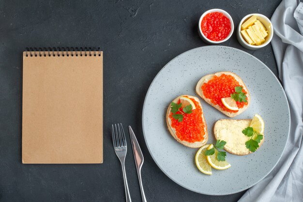 panini al caviale vista dall'alto con limone e formaggio sulla superficie scura