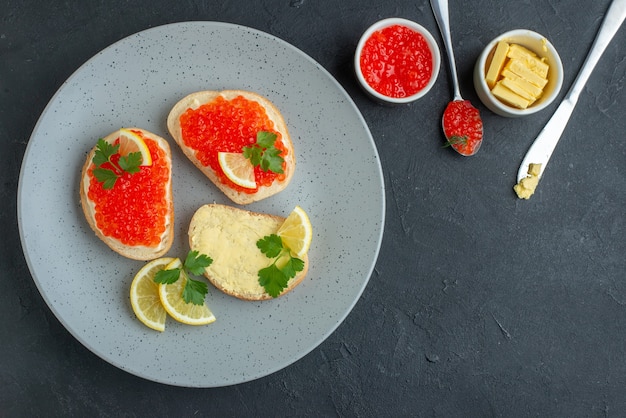 panini al caviale vista dall'alto con limone e formaggio sulla superficie scura