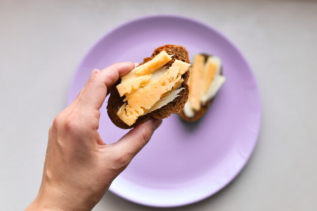 Panini Al Formaggio. per colazione. piatto multicolore. tavola. colazione fatta in casa. Panino al formaggio per la colazione su un tavolo bianco