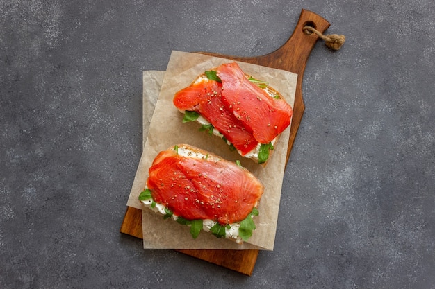 Panini aperti con salmone, rucola e formaggio bianco. Mangiare sano.