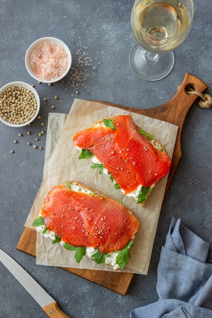 Panini aperti con salmone, rucola e formaggio bianco. Mangiare sano.