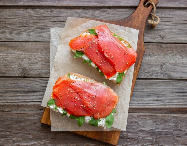 Panini aperti con salmone, rucola e formaggio bianco. Mangiare sano.