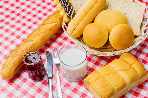 Panini assortiti con latte e marmellata di fragole