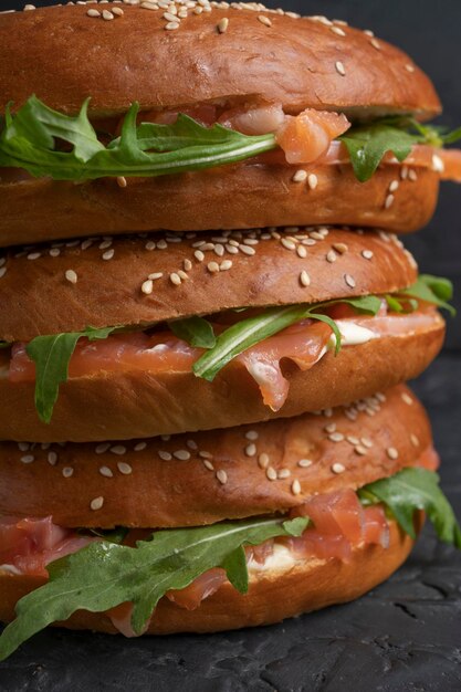 Panini Bagel con salmone e rucola su un tavolo da cucina scuro