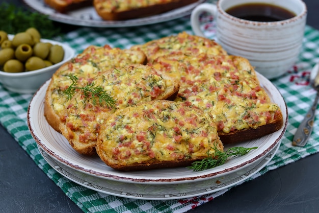 Panini caldi fatti in casa con formaggio e salsiccia in un piatto su una tovaglia a scacchi,