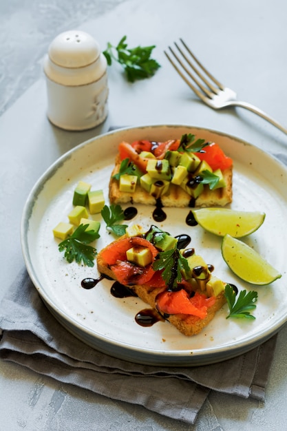 Panini con avocado e salmone con salsa balsamica e coriandolo. Vista dall'alto.