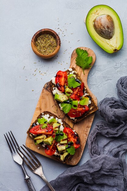 Panini con avocado, pomodorini e feta con salsa balsamica e coriandolo. Vista dall'alto.