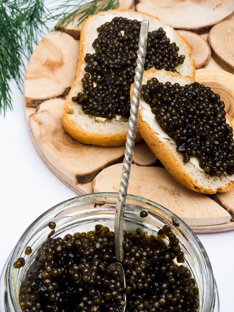 Panini con caviale nero un barattolo di caviale e un cucchiaio