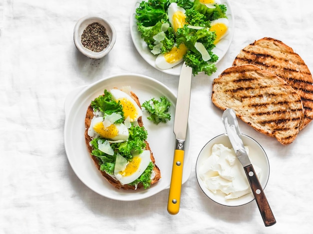 Panini con cavolo cappuccio e crema di formaggio e uova sode e ingredienti per cucinare su uno sfondo chiaro vista dall'alto