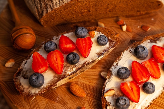 Panini con pane di segale fatto in casa, miele, formaggio e frutti di bosco