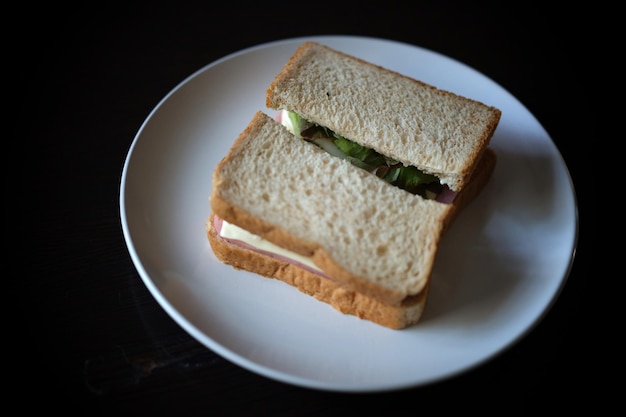 Panini con prosciutto all'uovo e formaggio tostato fritti in un piatto bianco