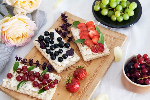 Panini con ricotta e frutti di bosco a bordo e fiori