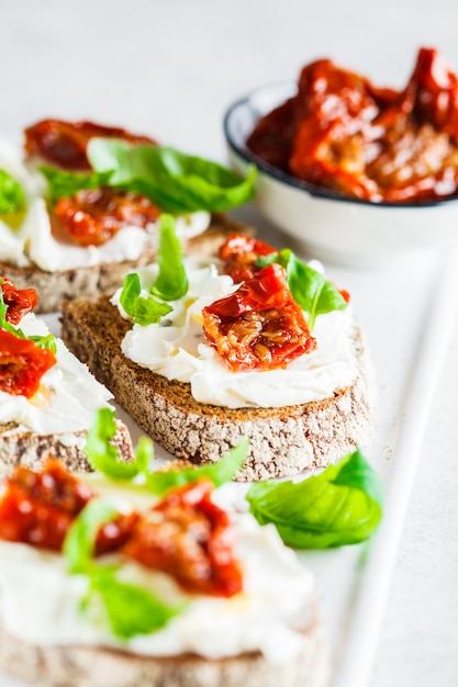 Panini con ricotta e pomodori sul bordo bianco