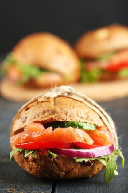 Panini con salmone e verdure su fondo di legno