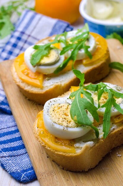 Panini con uova sode, pomodori gialli e rucola.