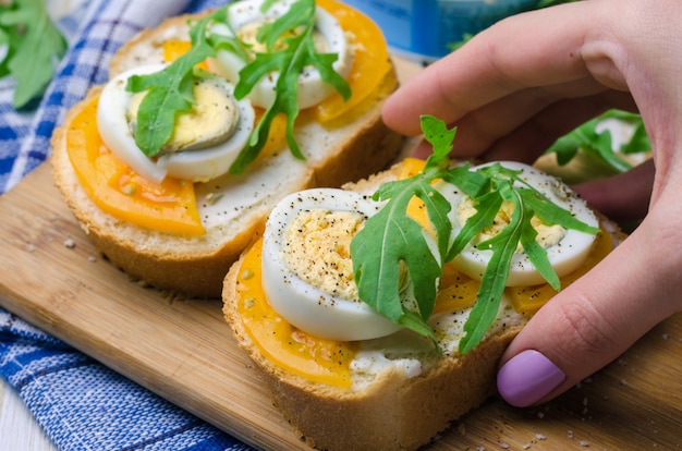 Panini con uova sode, pomodori gialli e rucola.