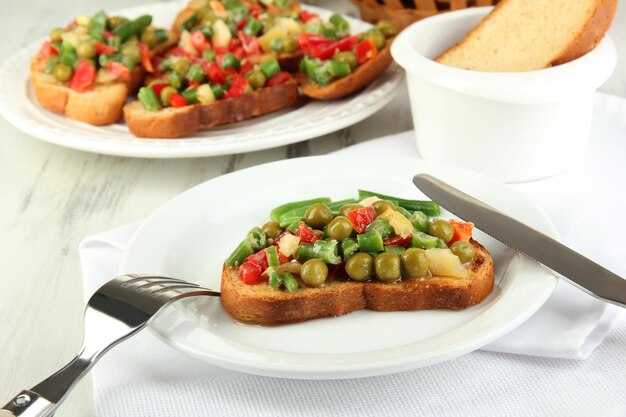 Panini con verdure e verdure sulla piastra sul primo piano della tavola di legno