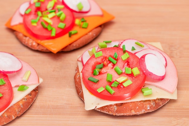 Panini croccanti con cracker con salsiccia di pomodoro, cipolle verdi e ravanello