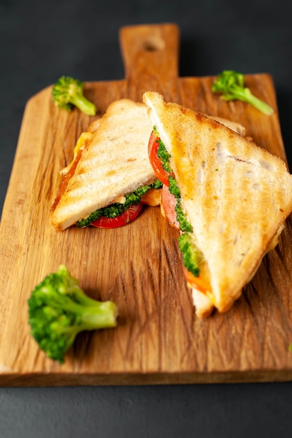 Panini del formaggio dei broccoli sul tagliere di legno, su calcestruzzo, fondo dell'ardesia