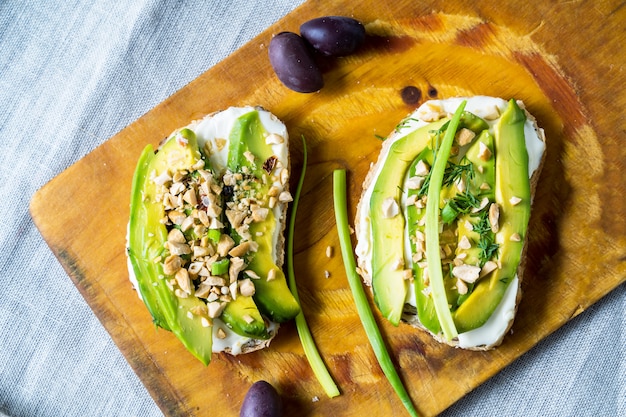 Panini di avocado con noci e crema di formaggio su un tagliere