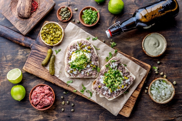 Panini di carne cruda su una tavola di legno