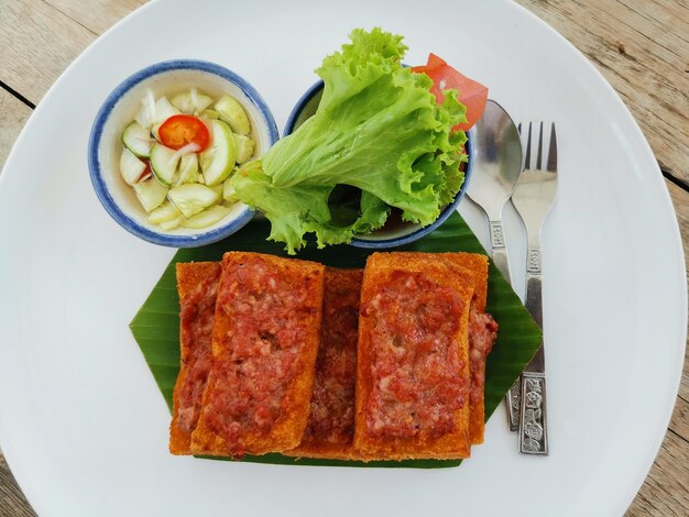 Panini di maiale serviti con salsa di verdure e aceto di cetriolo