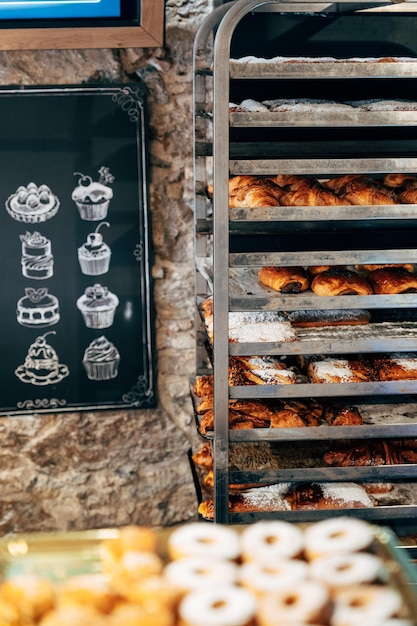 Panini dolci cosparsi di zucchero a velo giacciono sugli scaffali di una pasticceria