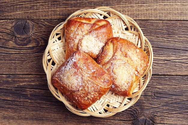 Panini dolci in piatto di vimini sul vecchio tavolo di legno Vista dall'alto