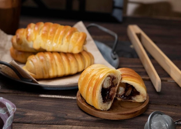 Panini dolci ripieni di cioccolato, formaggio, banane serviti in un piatto vintage di ferro. Sfondo scuro.