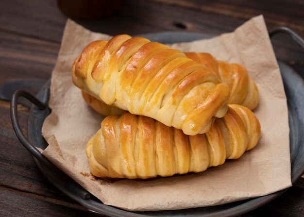 Panini dolci ripieni di cioccolato, formaggio, banane serviti in un piatto vintage di ferro. Sfondo scuro.