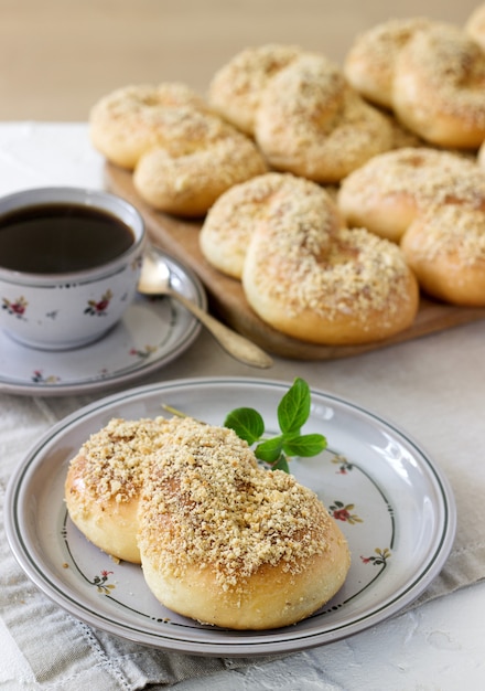 Panini dolci tradizionali rumeni e moldavi a forma di otto con glassa di miele e briciole di noci.