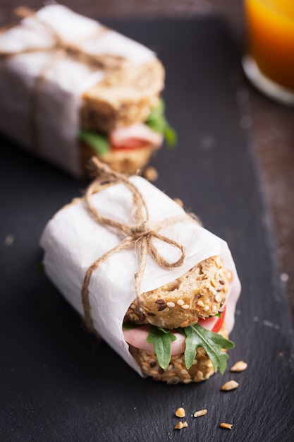 Panini fatti in casa preparati con pane integrale, verdure fresche e olio d'oliva