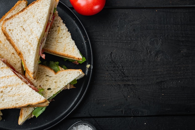 Panini freschi con ingredienti, sul tavolo in legno nero, vista dall'alto con copia spazio per il testo