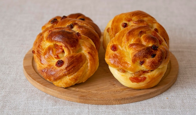 Panini freschi fatti in casa con albicocche secche e uvetta su una tavola di legno Messa a fuoco selettiva vista laterale