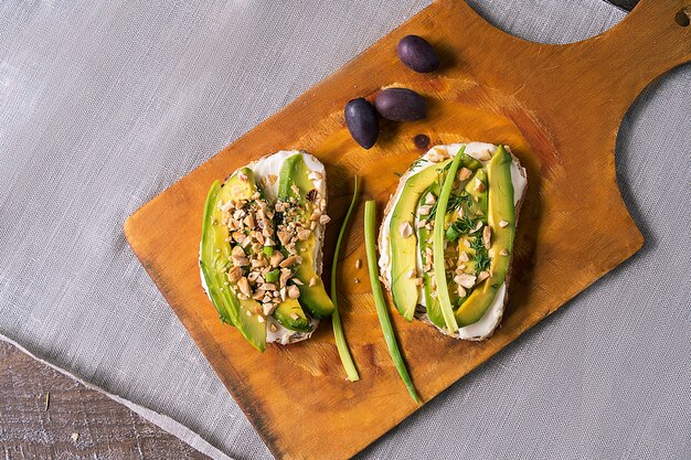 Panini o tapas con pane, crema di formaggio, verdure e condimenti gustosi. Cibo sano per pranzo o colazione. Copia spazio per il testo. Disteso.