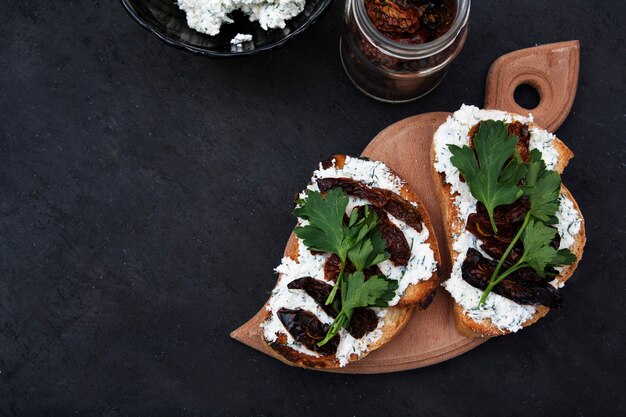 Panini piatti con crostini, ricotta e pomodori secchi