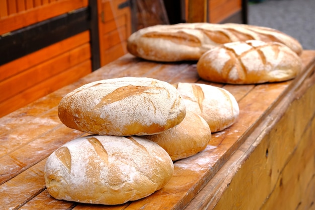 Panini rotondi di pane bianco al forno fresco su una tavola di legno sul mercato alimentare.