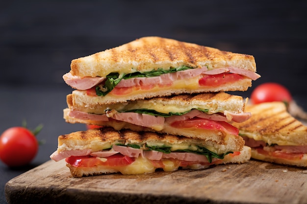 Panini sandwich club con prosciutto, pomodoro, formaggio e basilico.