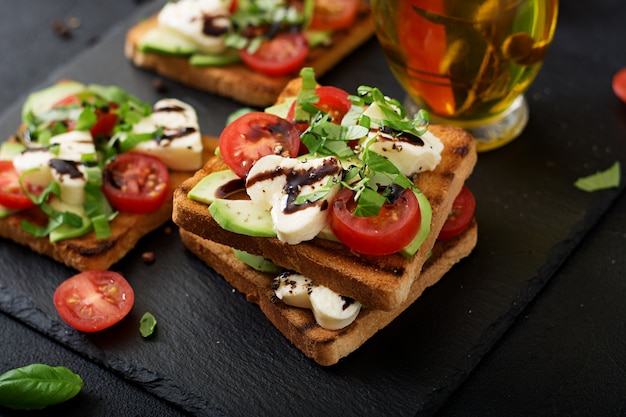 Panini sani con formaggio, pomodori, avocado e basilico