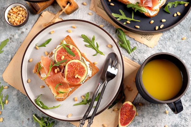 Panini sani di pane di segale con formaggio a pasta molle, jamon, fichi, rucola e pinoli.