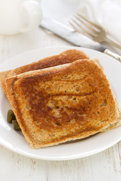 Panini sul piatto bianco sulla tavola di legno bianca