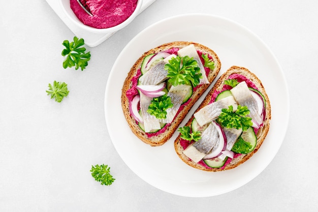 Panini tostati con aringhe salate e pate di barbabietole vista dall'alto