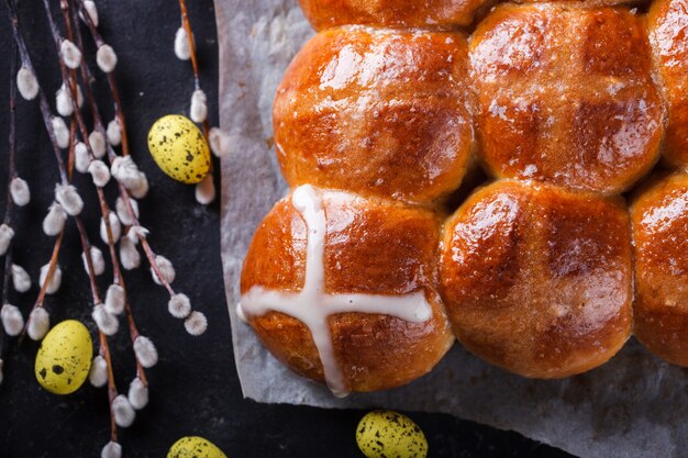 Panini trasversali caldi di Pasqua su uno sfondo scuro