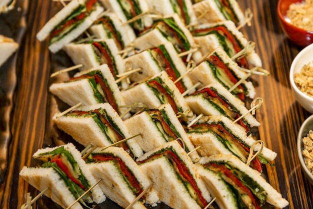 Panini triangolari appetitosi sul tavolo del buffet Catering per eventi vacanze e incontri d'affari Primo piano Fuoco selettivo